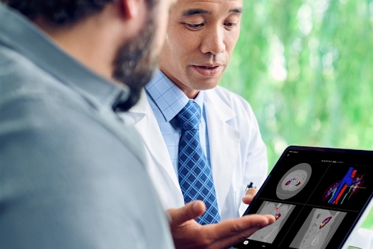 Patient and physician reviewing a digital 3D model and scans on a tablet