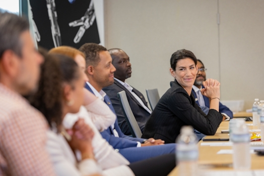 Group in an Intuitive meeting room at a table with a woman leaning in